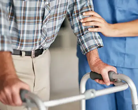 nurse stands beside a man in a hospital