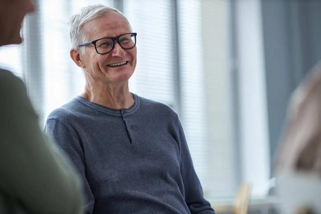 man with glasses and a friendly smile, relaxed in a chair