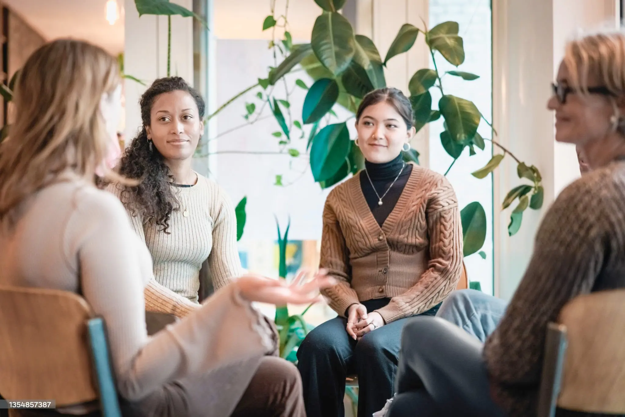 Three women engaged in conversation while sitting in a circle